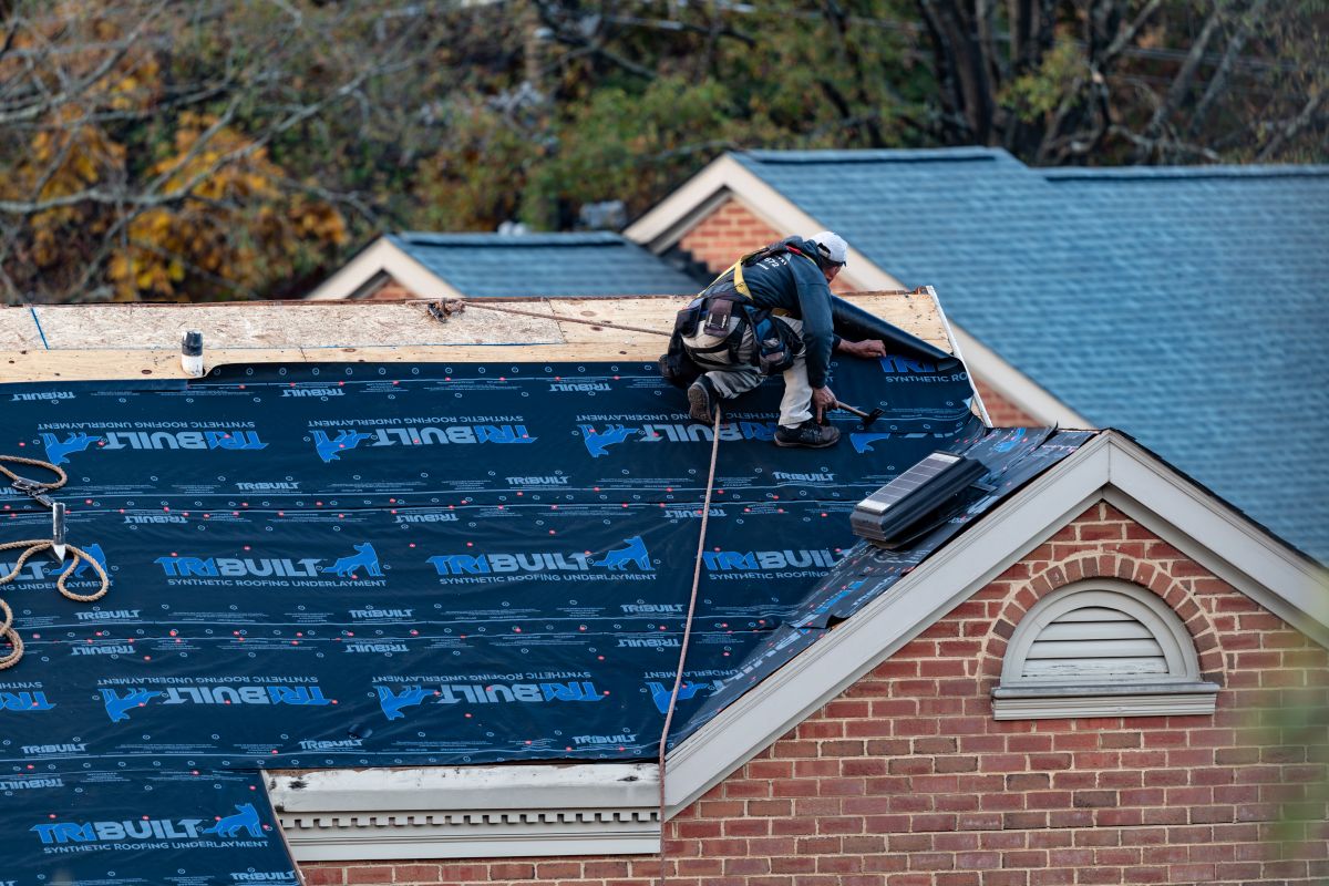 multifamily worker repairing roof