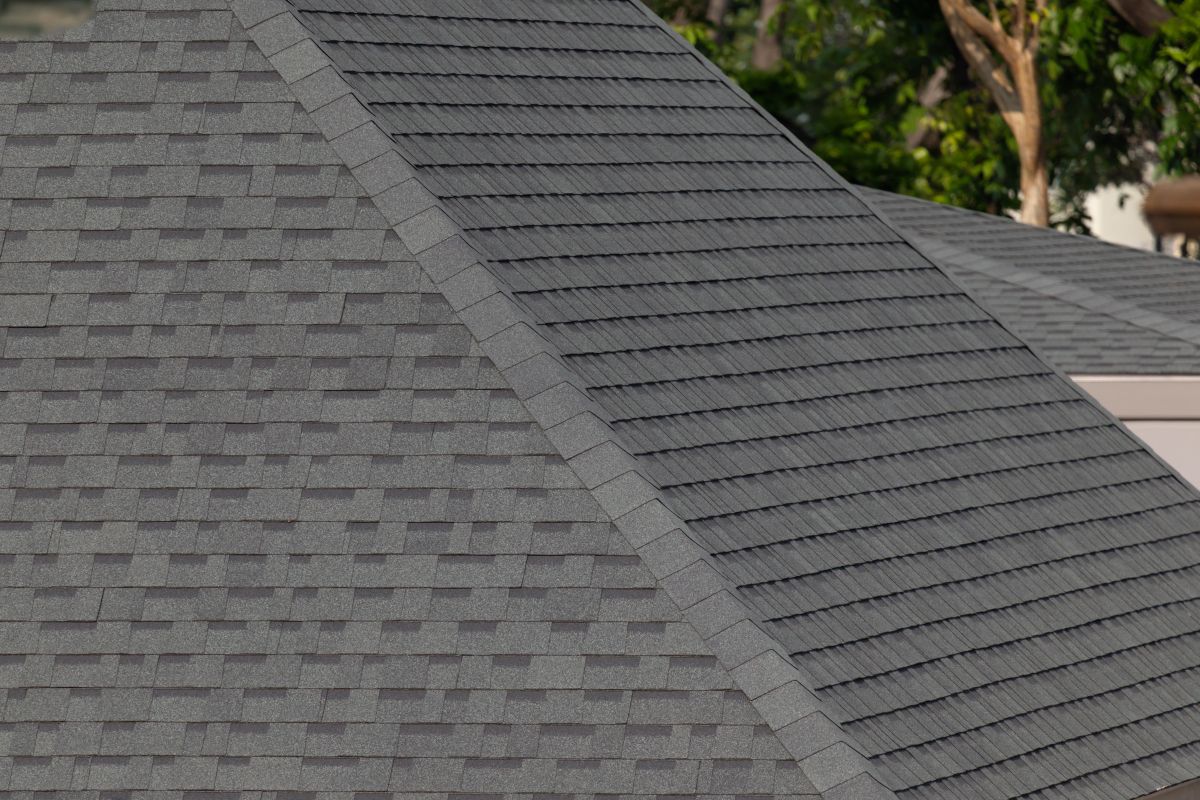 Dark gray shingles line a sloped roof with neat rows