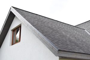 grey asphalt shingles roof with just installed wooden eaves