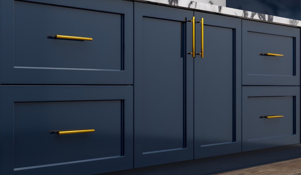 Navy blue kitchen cabinet doors and golden metal kitchen handles